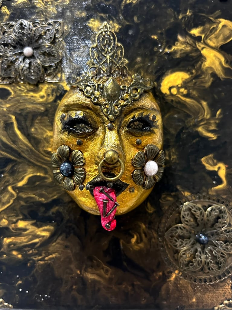 a gold mask with a face made out of gold leaf