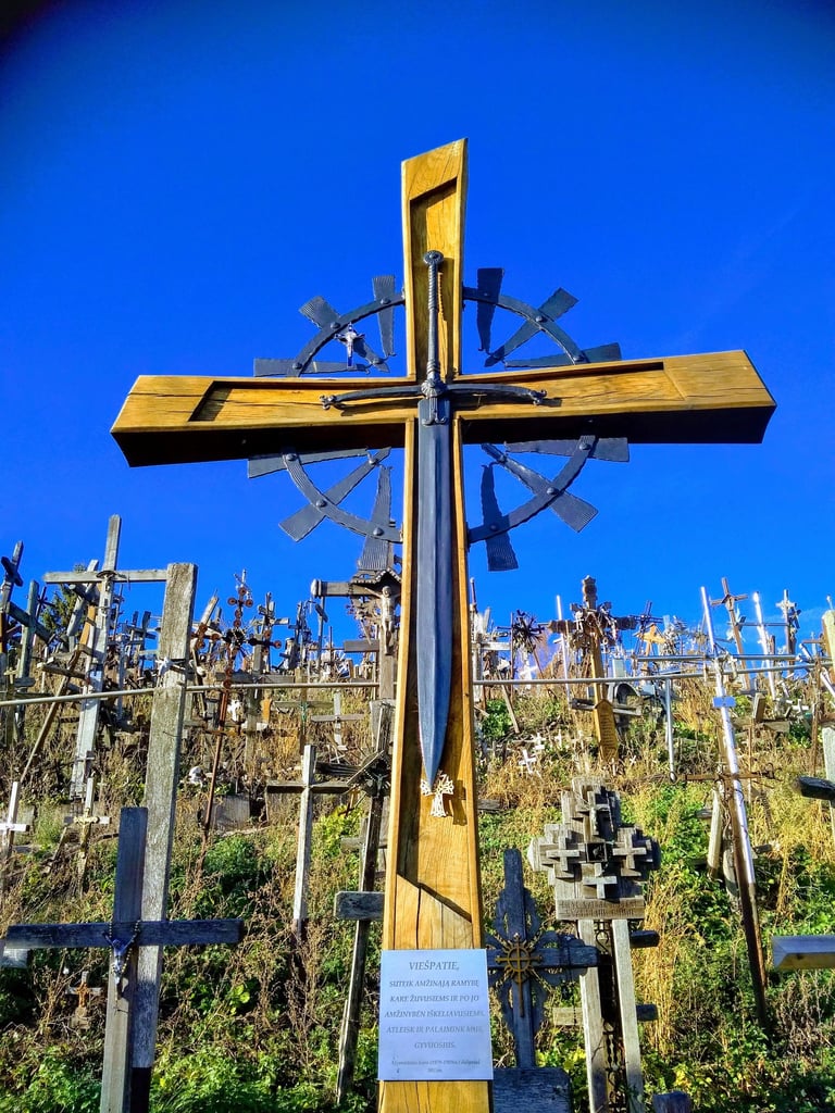 A large wooden cross with an inlaid sword at the Hill of Crosses pilgrimage site in Lithuania.