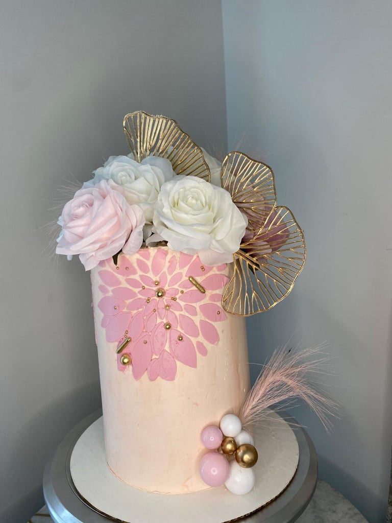 a cake with a pink and gold flower arrangement