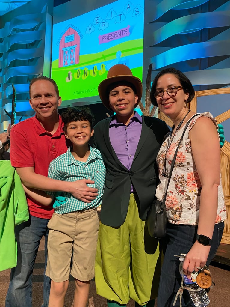 a family posing for a picture in front of a screen