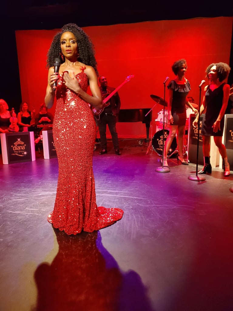 a woman in a red dress standing in front of a microphone