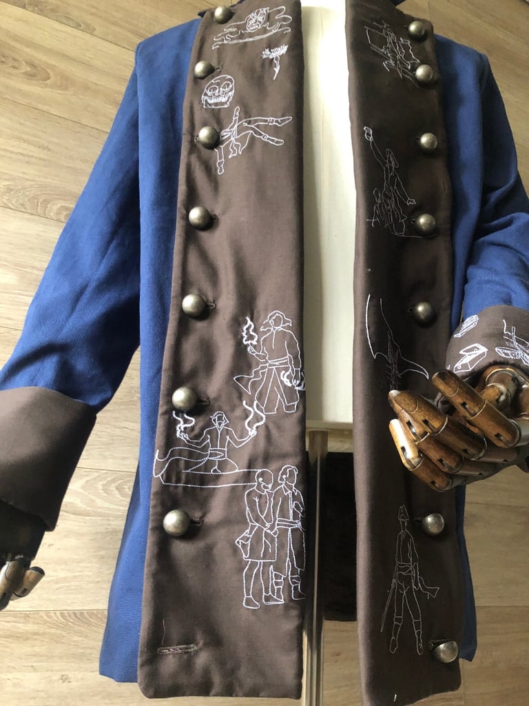 Veste de pirate dont l'histoire est raconté en broderies sur les revers de sa tenue