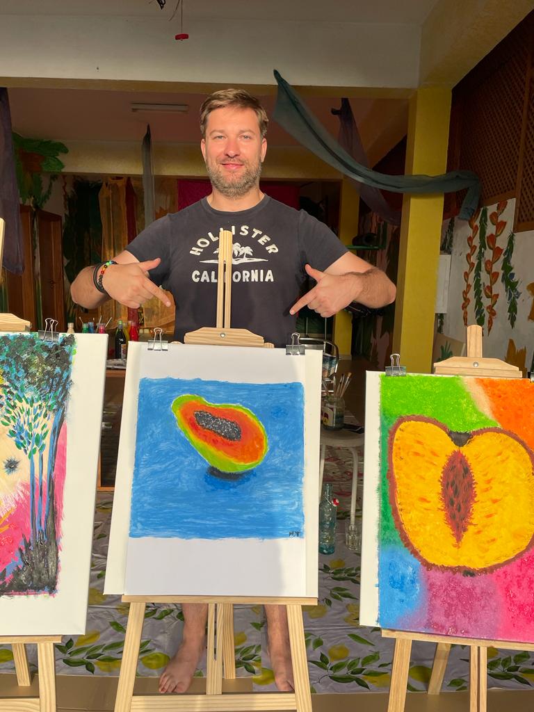 a man standing in front of a display of art work