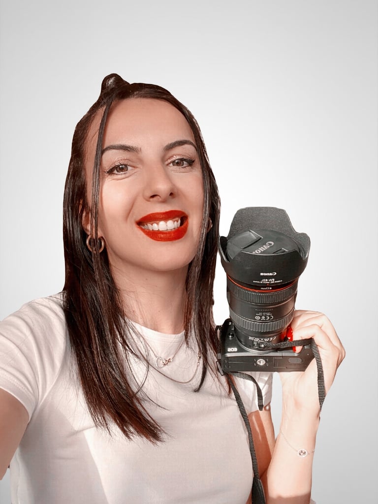 a woman holding a camera and smiling