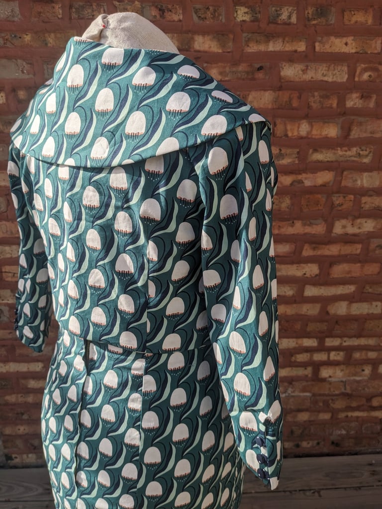 The back of a green art nouveau reversible sheath dress and 50's inspired cropped jacket