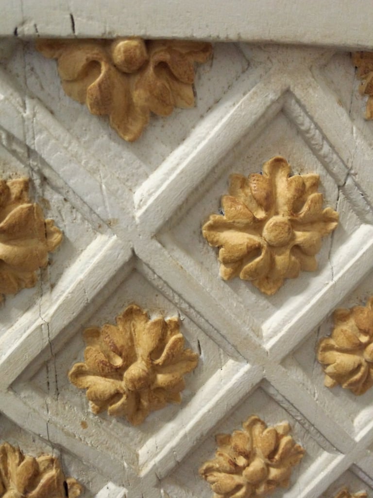 Fleurs de lys sculptées en bois et peintes sur un buffet d'époque