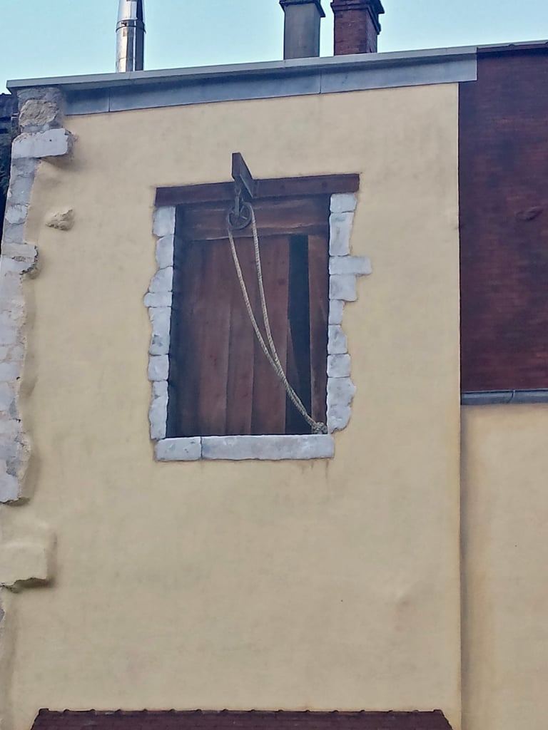 Fenêtre d'atelier peinte en trompe-l'oeil sur une façade à Moirans-en-Montagne dans le Jura, 39.