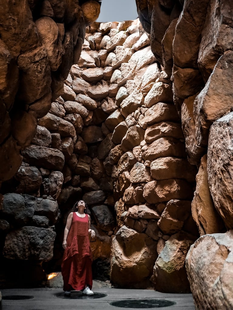 Woman visiting the interior of Nuraghe La Prisgiona, Arzachena Sardinia