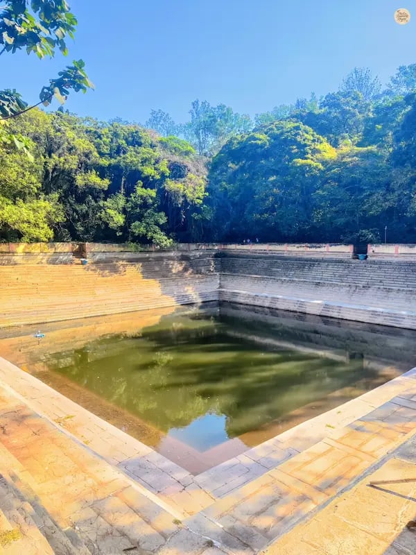 Amrita Sarovar, a symmetrical stepped pond at Nandi Hills, surrounded by stone steps and greenery