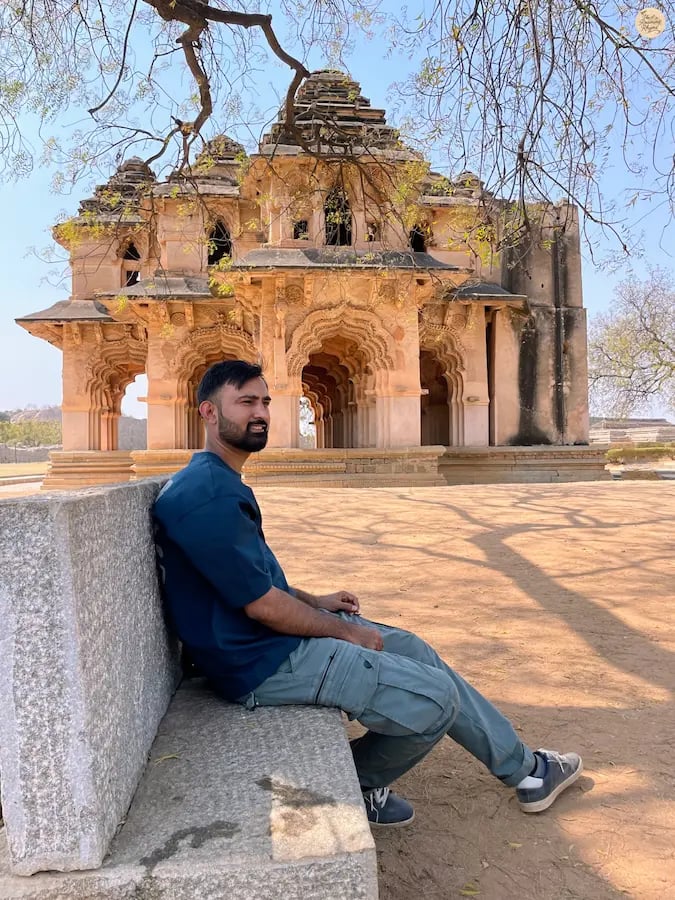 Person sitting by Lotus Mahal in Hampi, soaking in its royal silence.
