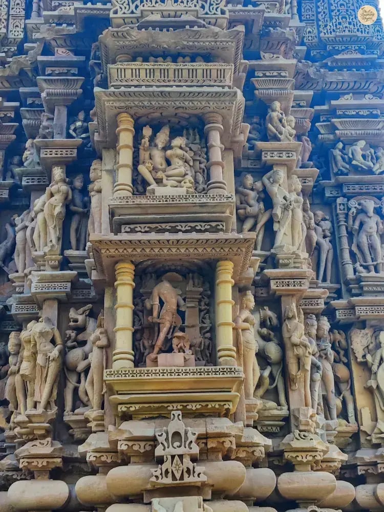 Detailed carvings on the outer wall of Vamana Temple Khajuraho showing daily life scenes.