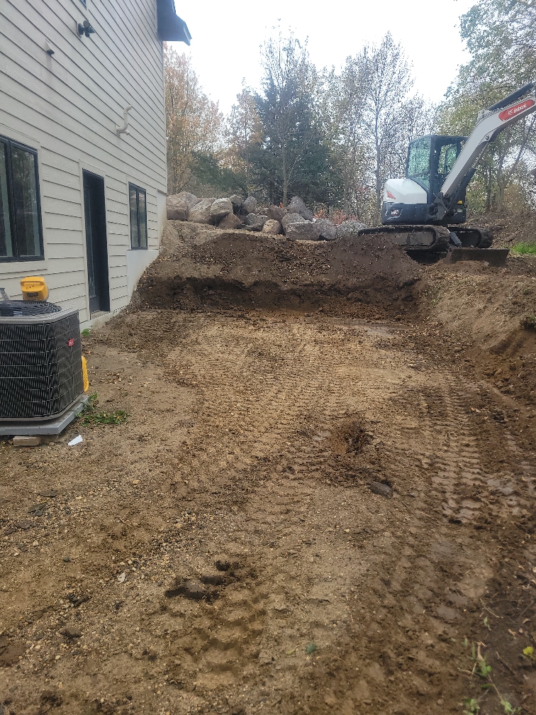 bobcat excavator digging dirt for boulder wall