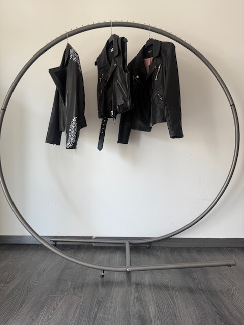 Espositore con appesi 3 giubotti in pelle neri  vista frontale