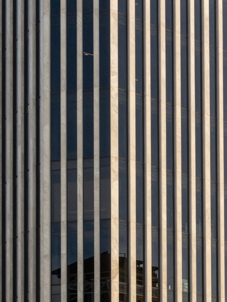 Elegant minimalist architectural detail of a modern corporate office building in São Paulo, soft daylight reflecting on glass and concrete, professional tone, 35mm