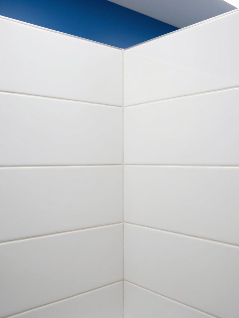 Close-up of pristine white tile grout lines in a modern commercial restroom, bright high-key commercial lighting, sharp focus