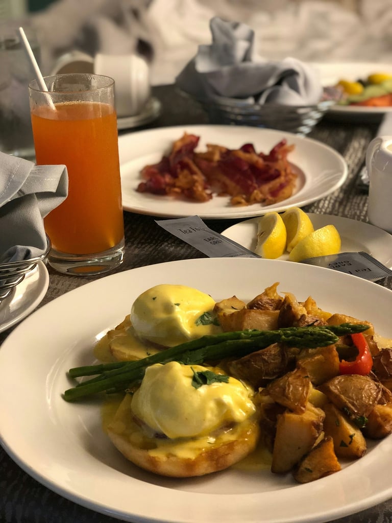 Hotel room service breakfast. Orange, bacon,potato, asparagus,lemon on plate.Guest Experience 