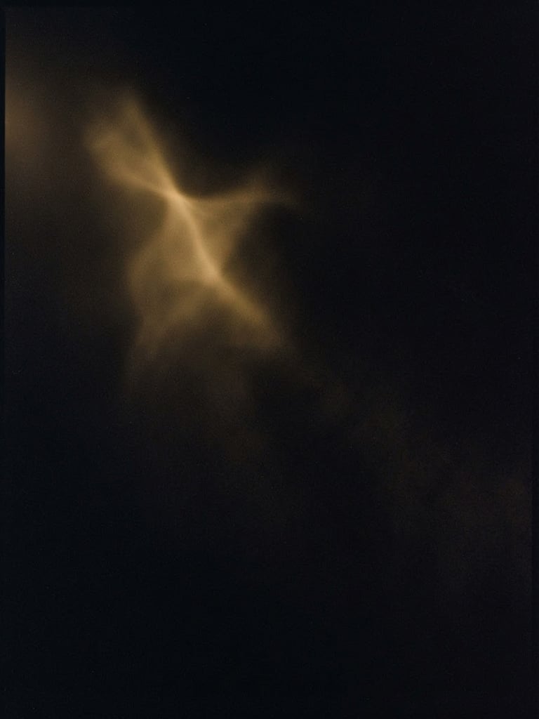 Faint golden light leak emerging from deep black shadows, abstract mysterious atmosphere, soft focus, 35mm film grain, minimalist composition