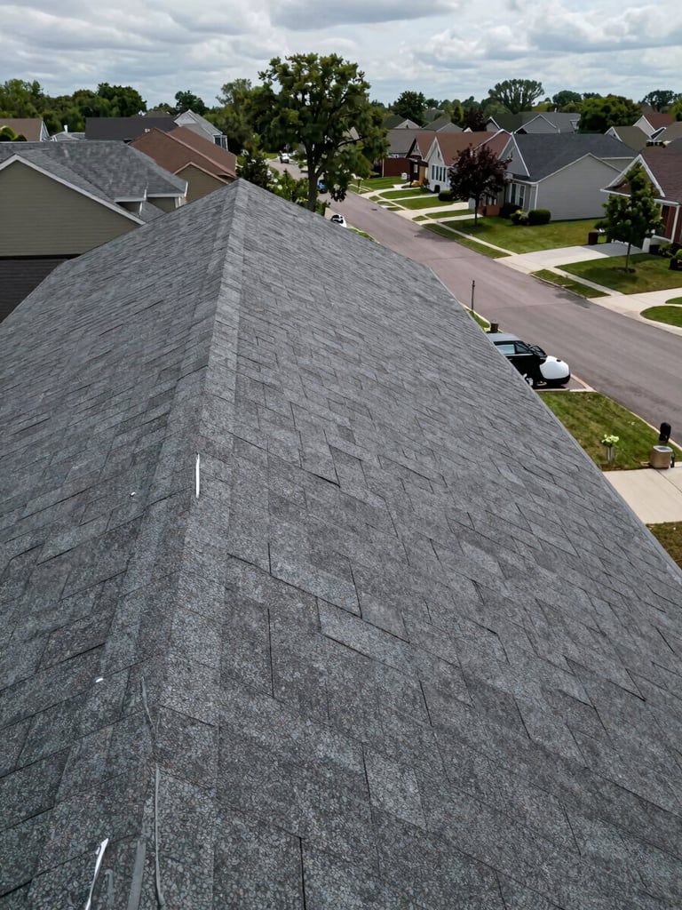 Wide environmental shot of a freshly completed residential roof replacement, photographed from the street — full roof line visible, clean architectural shingle rows running to a sharp ridge, overcast daylight, no people, DC suburban neighborhood backdrop