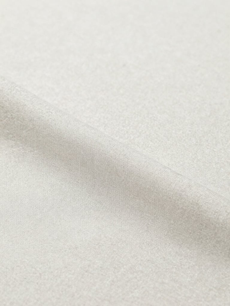 Close-up studio shot of a tactile, neutral-colored cotton fabric with visible weave texture, bright even lighting, soft shadows, crisp focus, minimalist, portrait aspect.