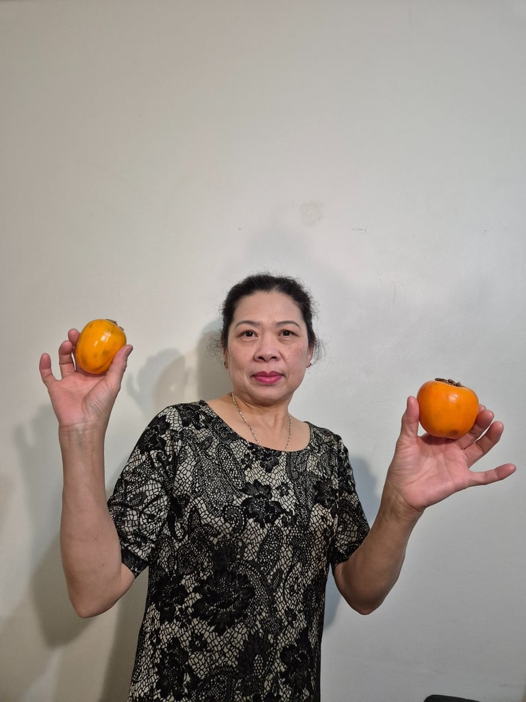 a woman holding two persimmons in her hands