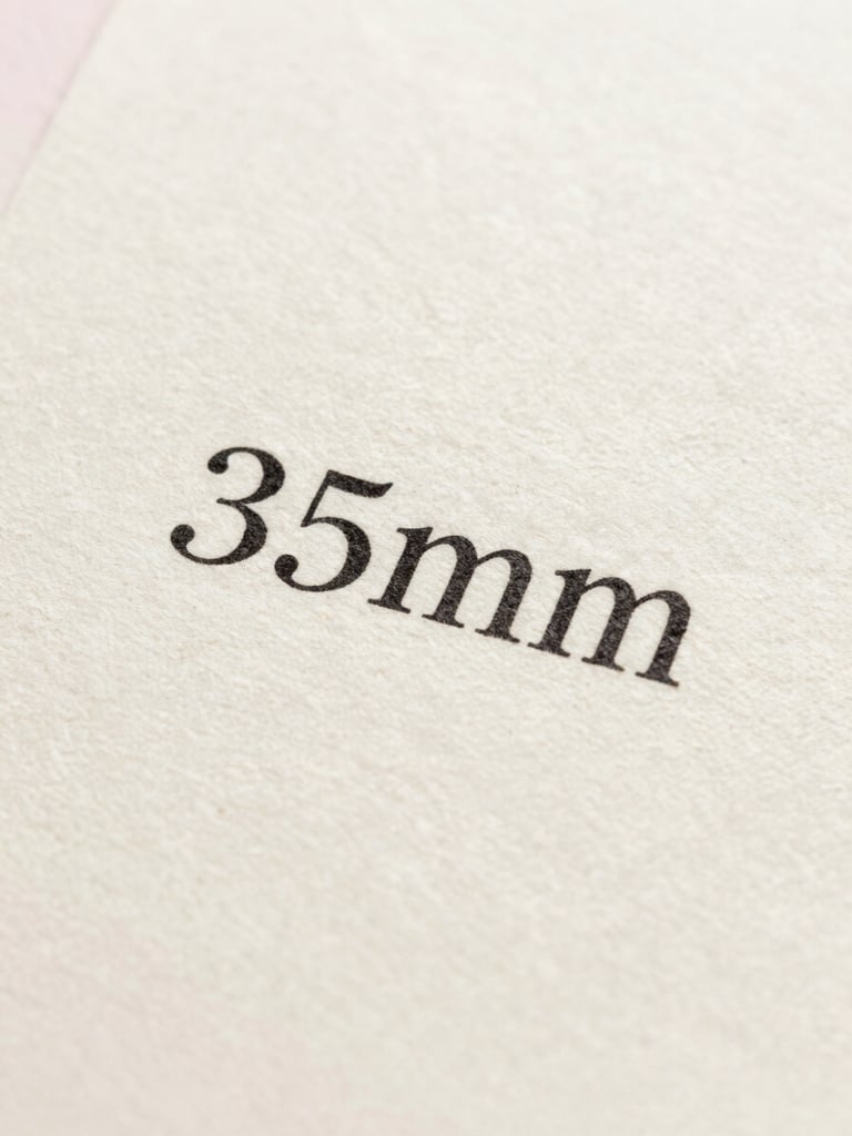 Macro shot of printed black ink text on textured cream cotton paper, soft shadows, elegant serif typography, bright natural light, 35mm