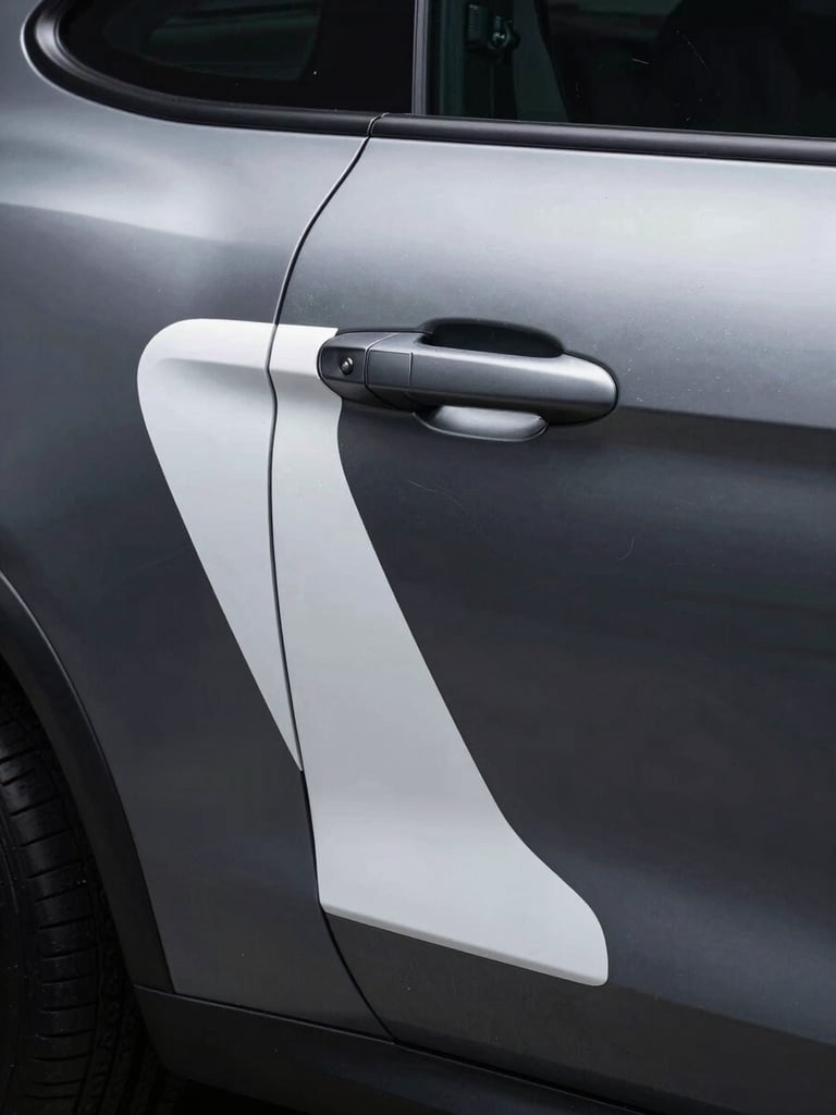 Tall portrait — close study of a vehicle's rear quarter panel where a custom graphic wraps precisely around a compound curve and door handle recess. The vinyl edge is immaculate, following the body crease with surgical accuracy. Cold studio strobe lighting from the upper left sculpts the surface, revealing the graphic as a three-dimensional architectural decision rather than a flat decal. Dark charcoal vehicle surface, white and silver graphic elements. No people, no distracting backgrounds.