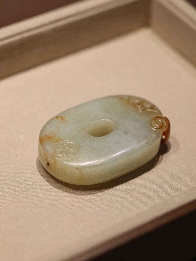Macro close-up of ancient jade with soft side-light, showing rich patina, resting on a silk scholar's tray, warm scholarly setting, muted tones.