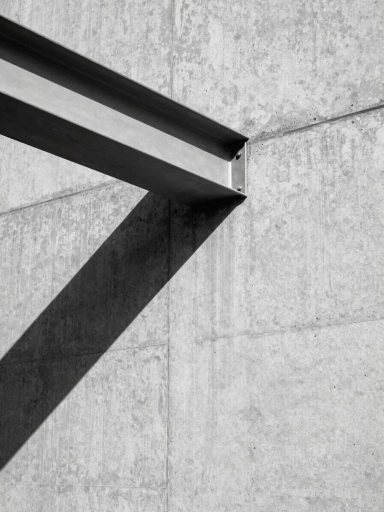 High-contrast black-and-white architectural photograph of a raw concrete wall meeting a sharp steel beam at a 45-degree angle, hard directional sunlight casting a razor-sharp shadow, orthographic composition.