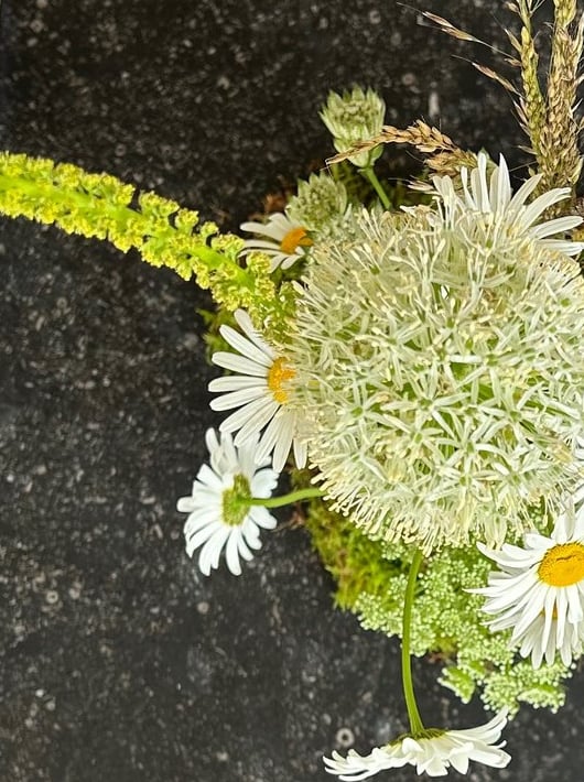 vue du dessus d'une. composition de table avec des anthemis et des album blanc 