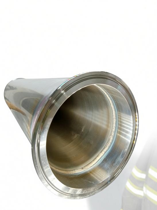 Close-up of a completed sanitary stainless steel weld on a tri-clamp ferrule for piping.