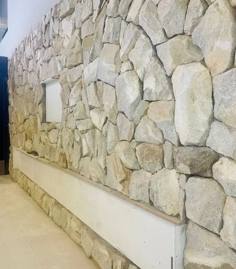 Pedra moledo branca, amarela, cinza caco almofadada irregular assentadea na parede interna e externa