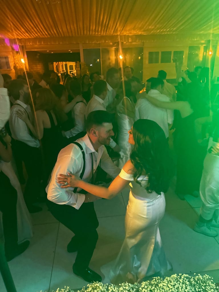 Bride and groom dancing to LuxeBand at their wedding with guests on the dance floor