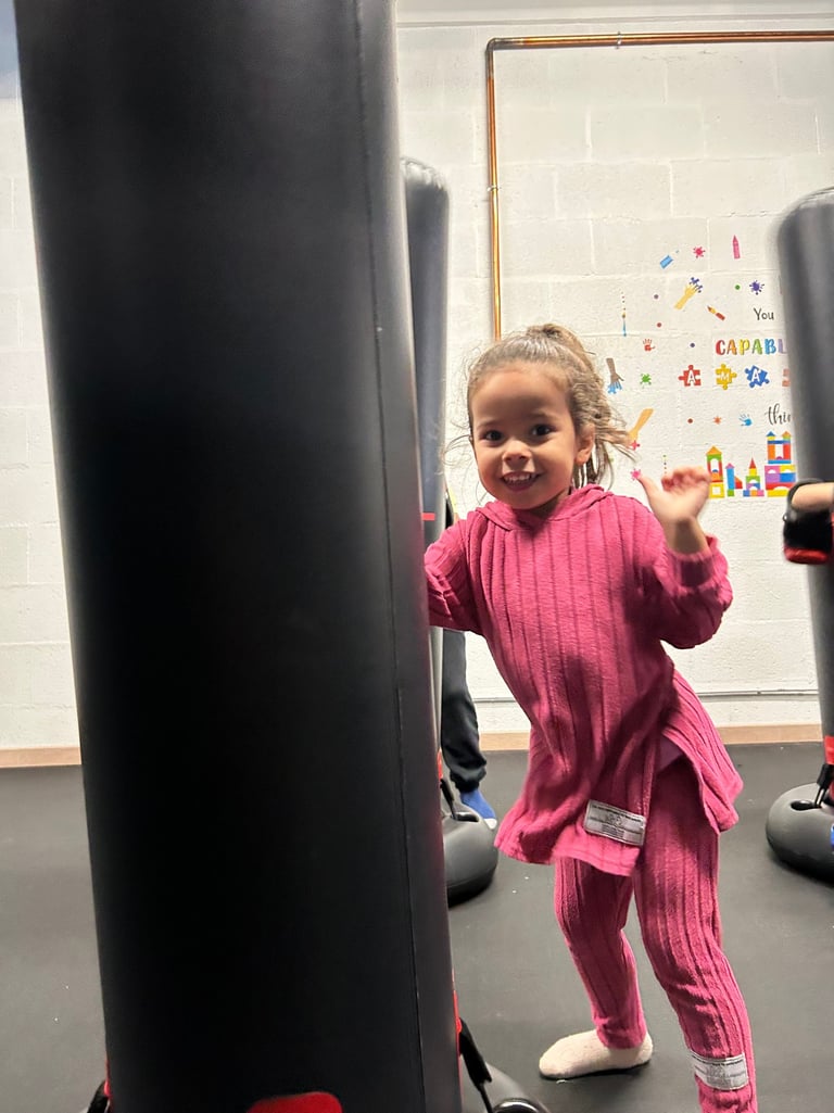 petite fille qui fait de la boxe en souriant 