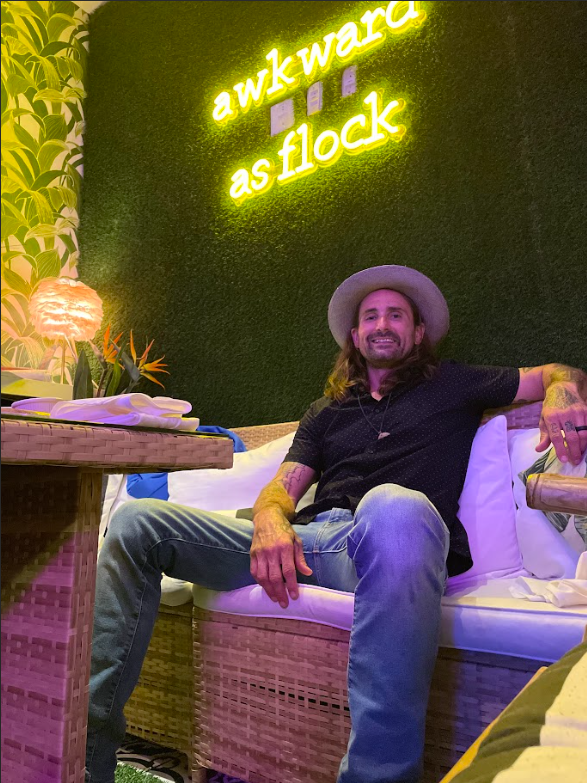 a man sitting on a couch with a hat on