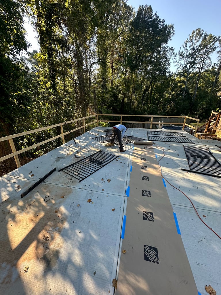 a man repairing a fence with metal on the floor of the driveway