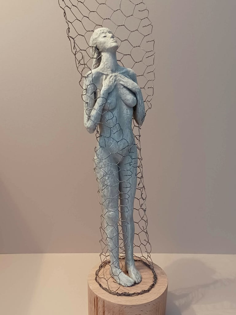 A standing female figure, leaning back with eyes closed, surrounded by a wire netting enclosure
