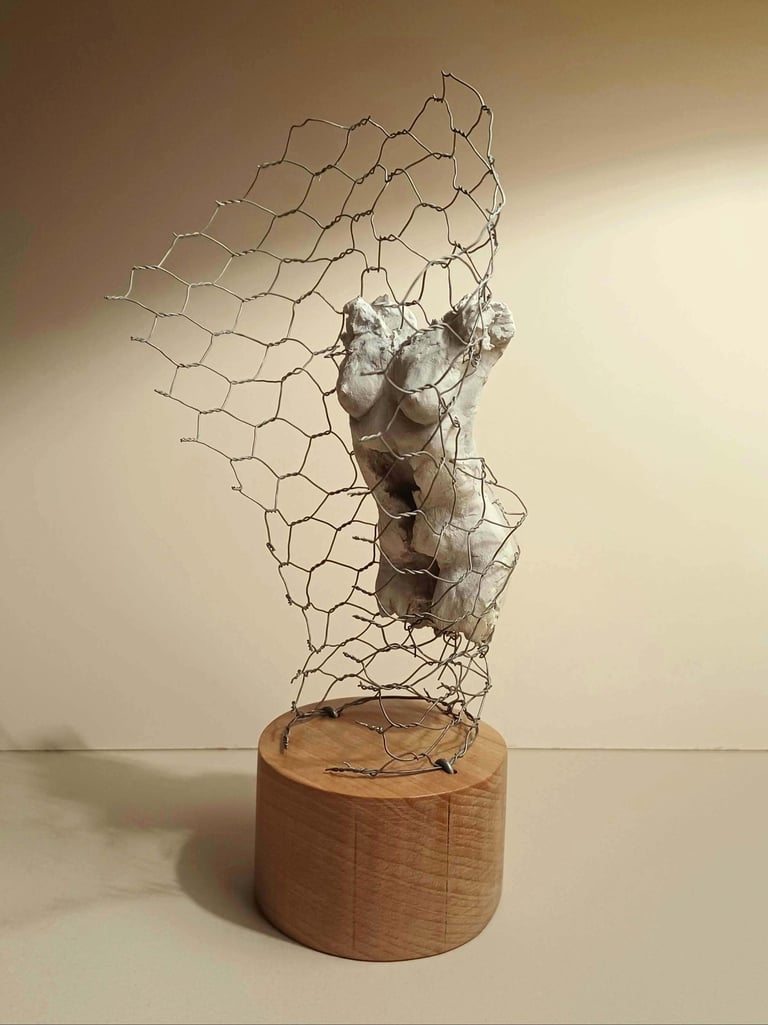 A clay female torso surrounded by wire netting, painted in neutral colours