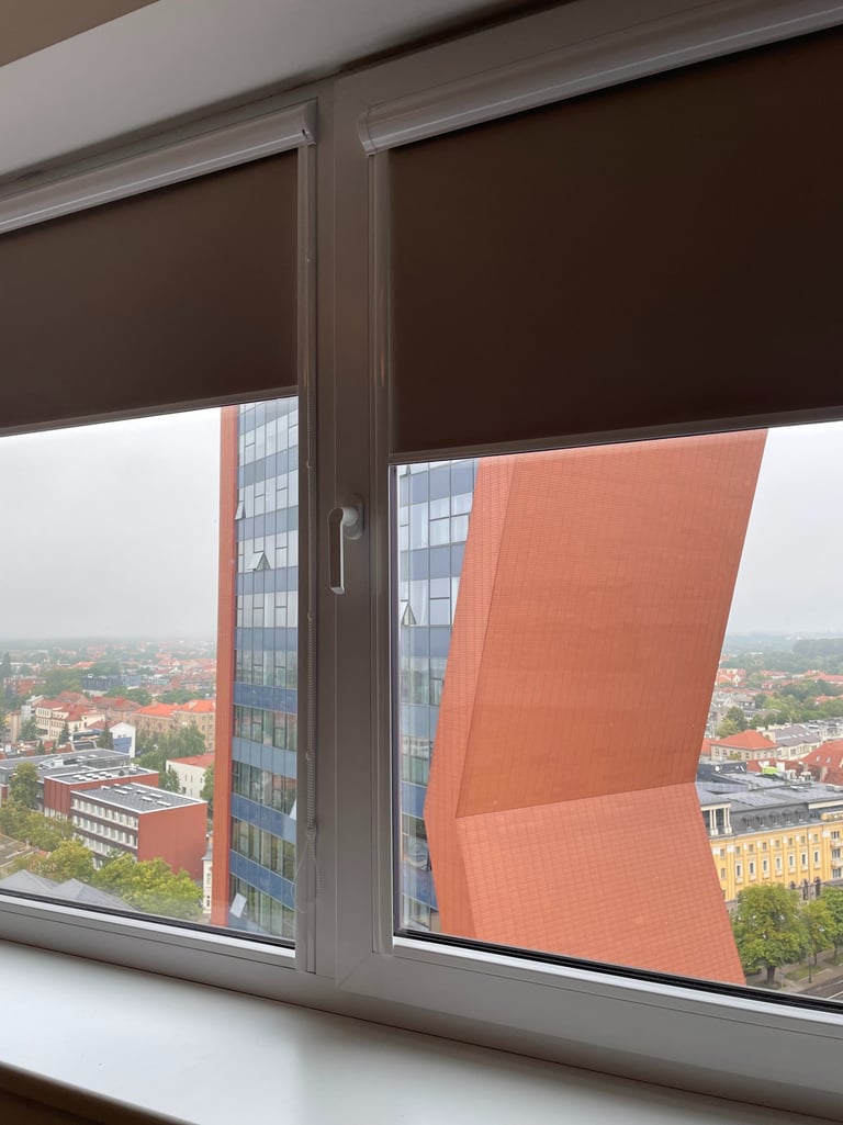 alt="Klasikiniai roletai miegamajame su tamsesniu audiniu"