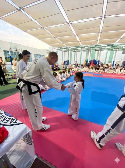Student receiving belt at Hwa Rang Taekwondo grading exam Dubai