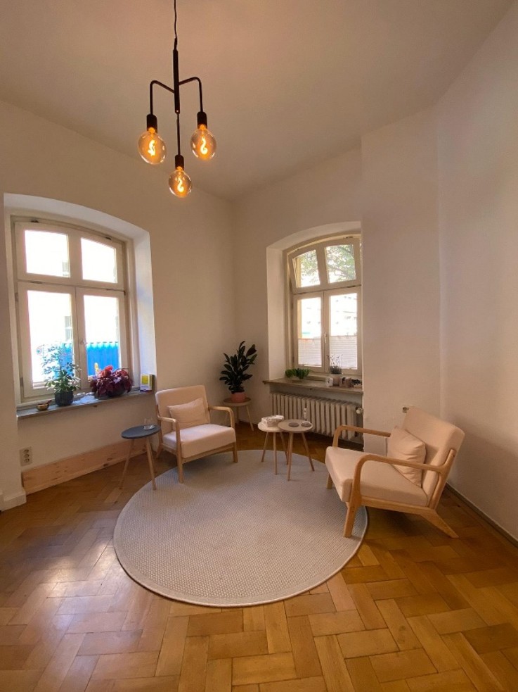 Schöner Praxisraum mit zwei Stühlen und Parkettboden in einem Altbau