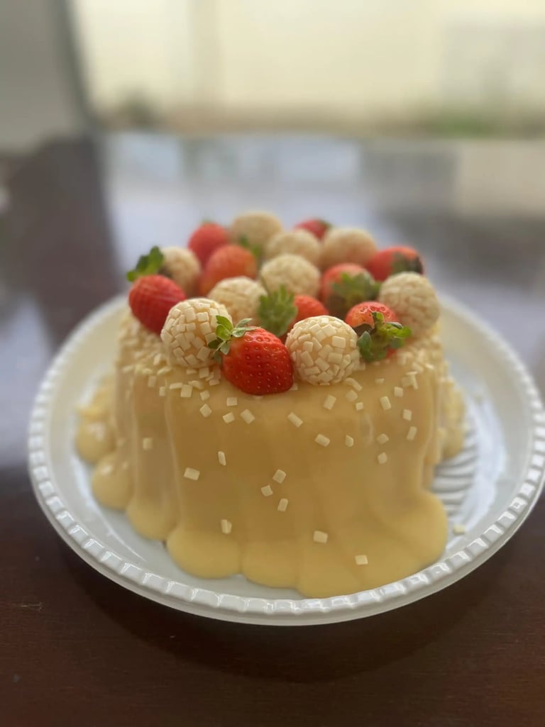 Deliciosa sobremesa com cobertura de doce de leite, decorada com morangos e bombons brancos, ideal p