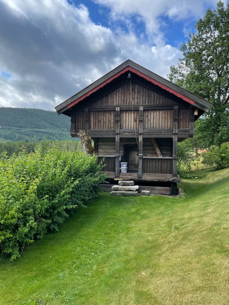 A wooden building, stabbur, with hills in the background-Telelaget