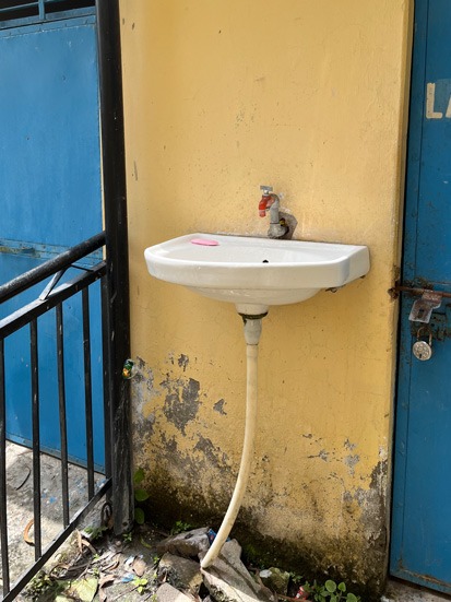 Small basin with single tap on yellow wall.