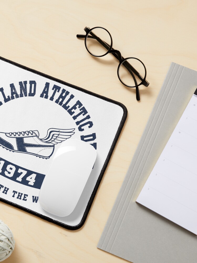 Retro 1974 athletic-style custom mouse pad on a desk with glasses.