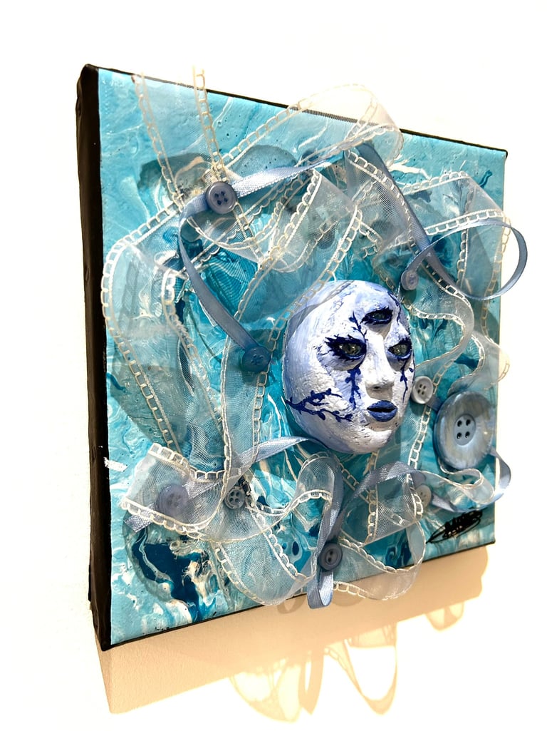 Ilona Paris tableau d'une sculpture d'un visage bleu avec trois yeux et du tissu autour