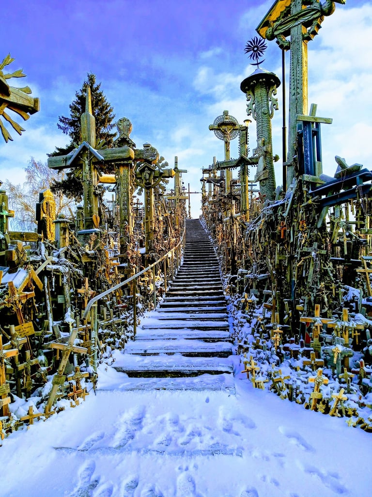 Snow-covered stairs leading up the Hill of Crosses, a famous pilgrimage site in Lithuania.