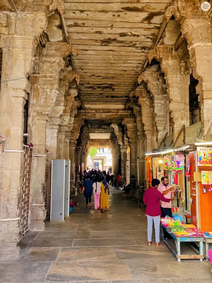 Grand entrance corridor of Jambukeshwar Temple, Thiruvanaikaval, with devotees gathered for morning darshan.