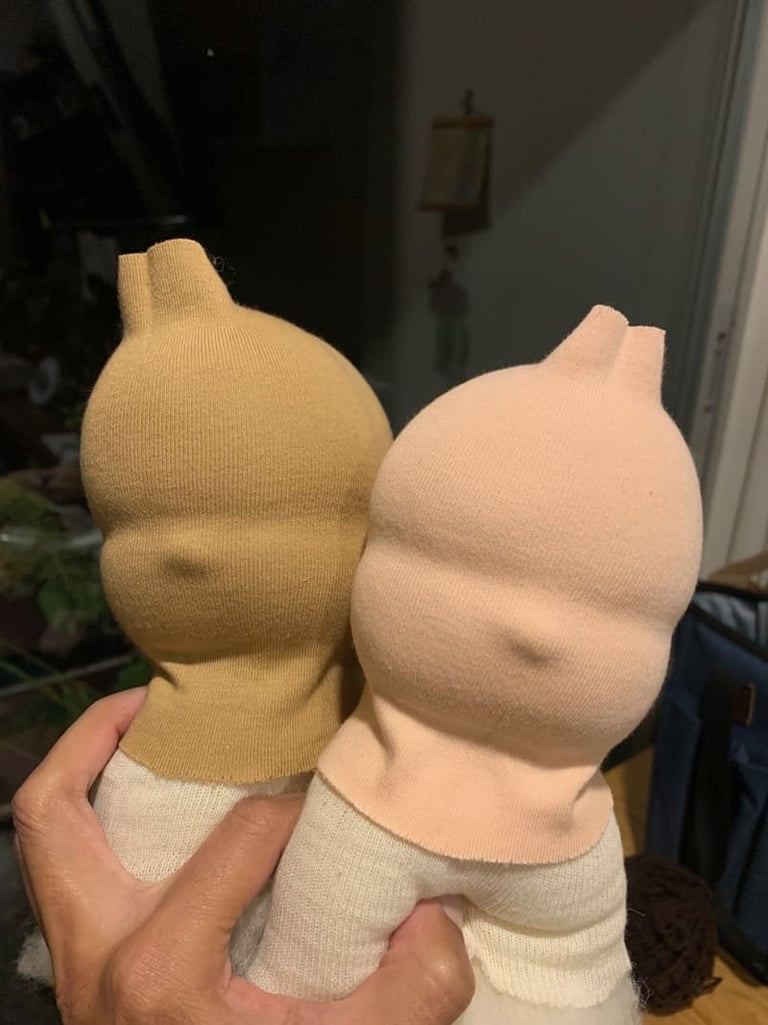 Dos cabezas muñecas Waldorf en proceso hechas a mano en tonos neutros beige y durazno.