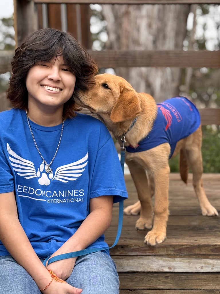 A cute puppy nuzzles his puppy raisers ear while she smiles
