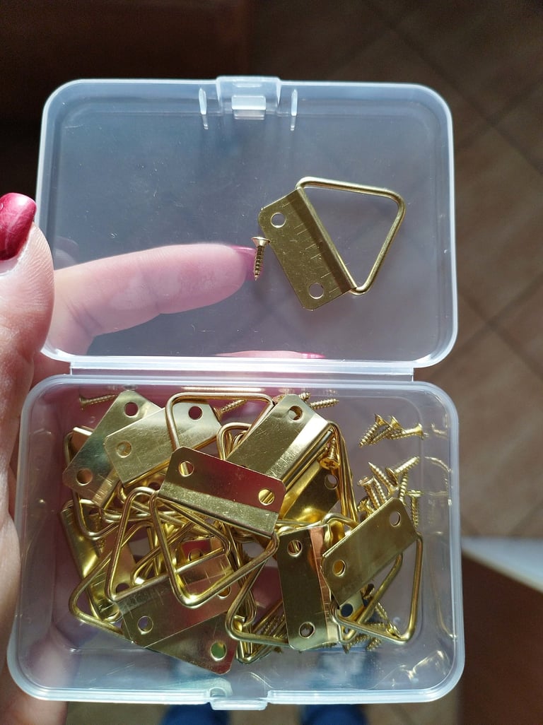 Set of 20 golden two-hole triangular picture hooks with mounting screws for hanging framed artwork 